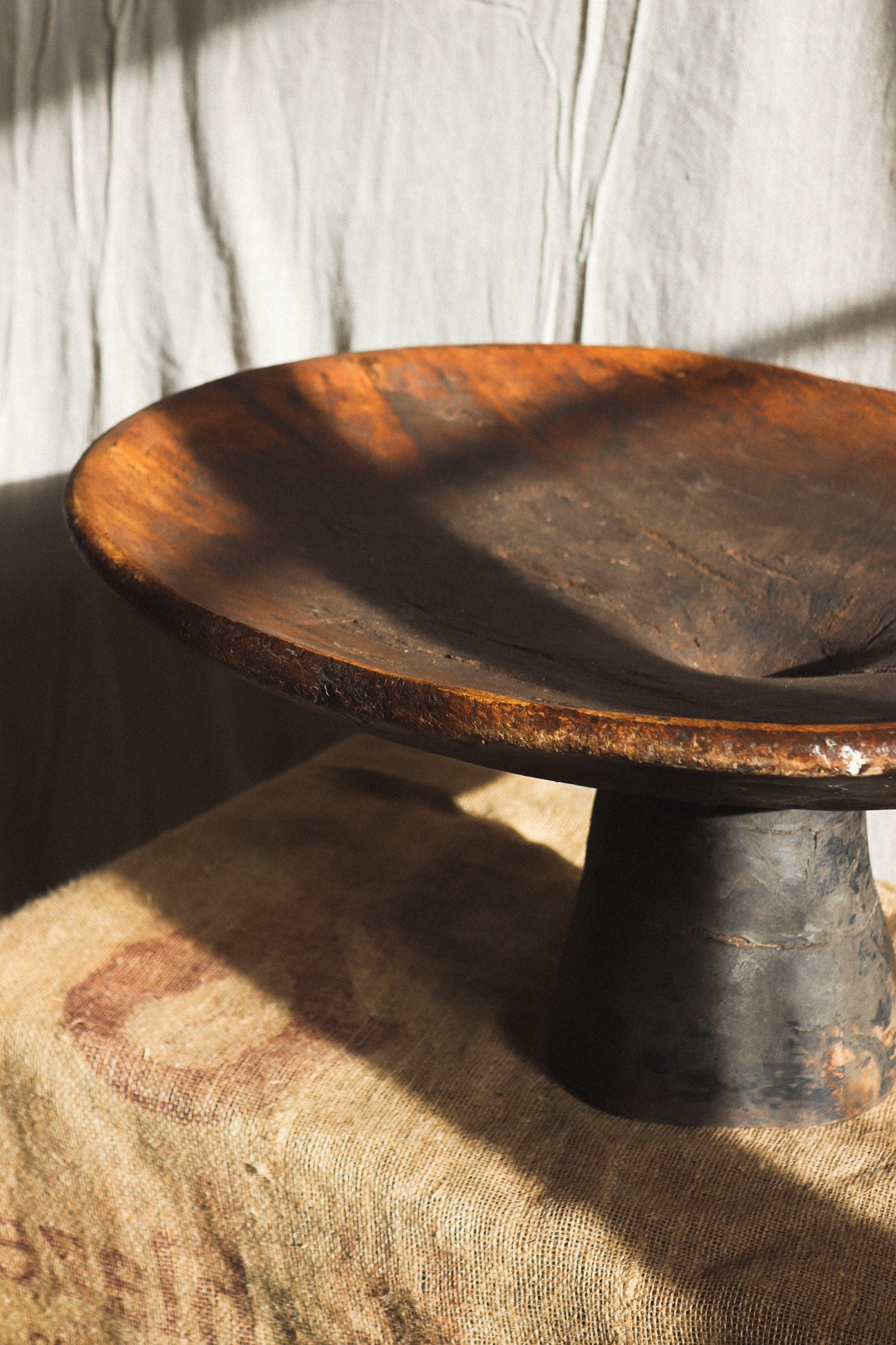 Wooden bowl on a pedestal with a textured background