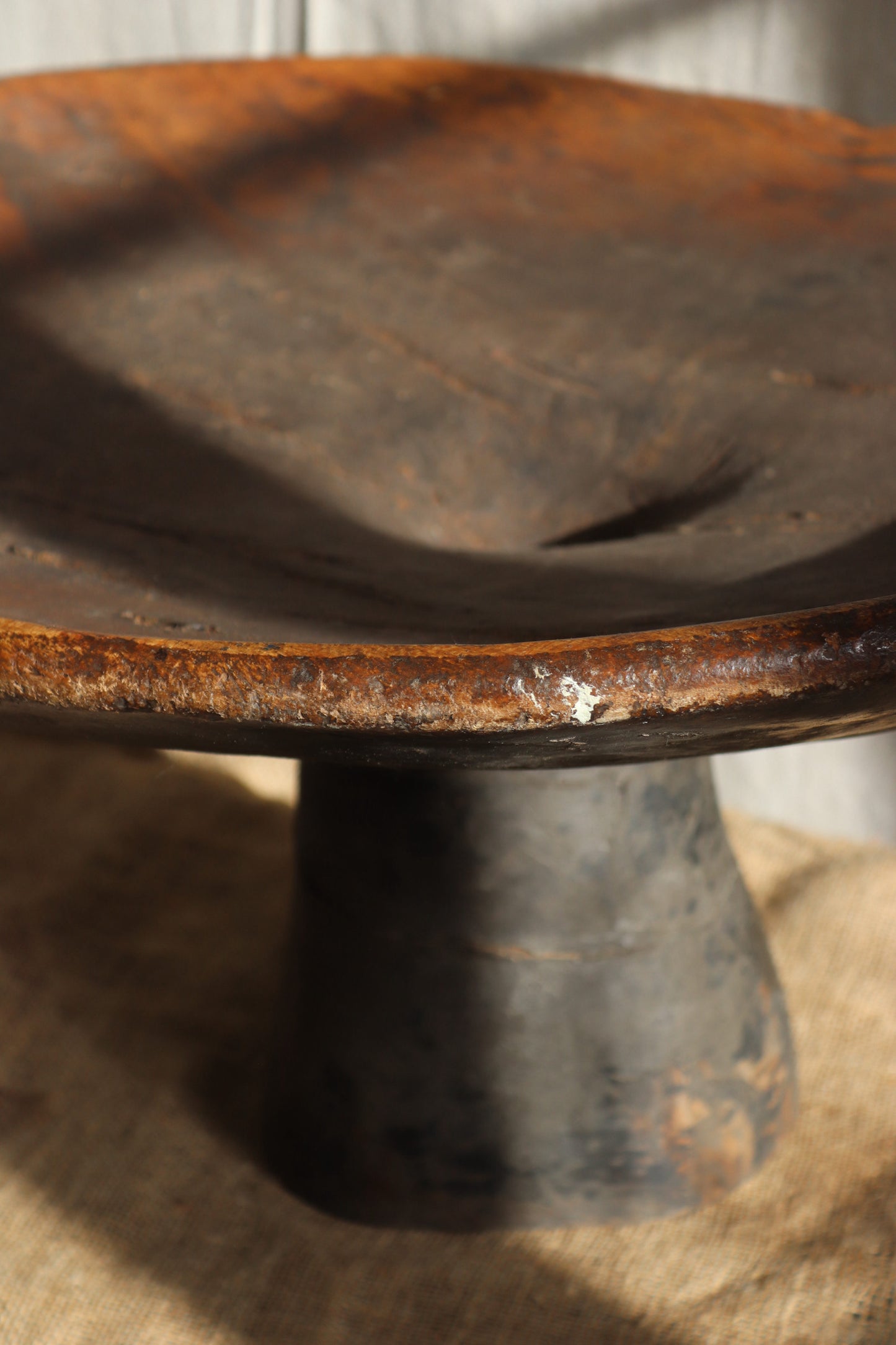 Rust-covered metal pulley wheel on a wooden surface