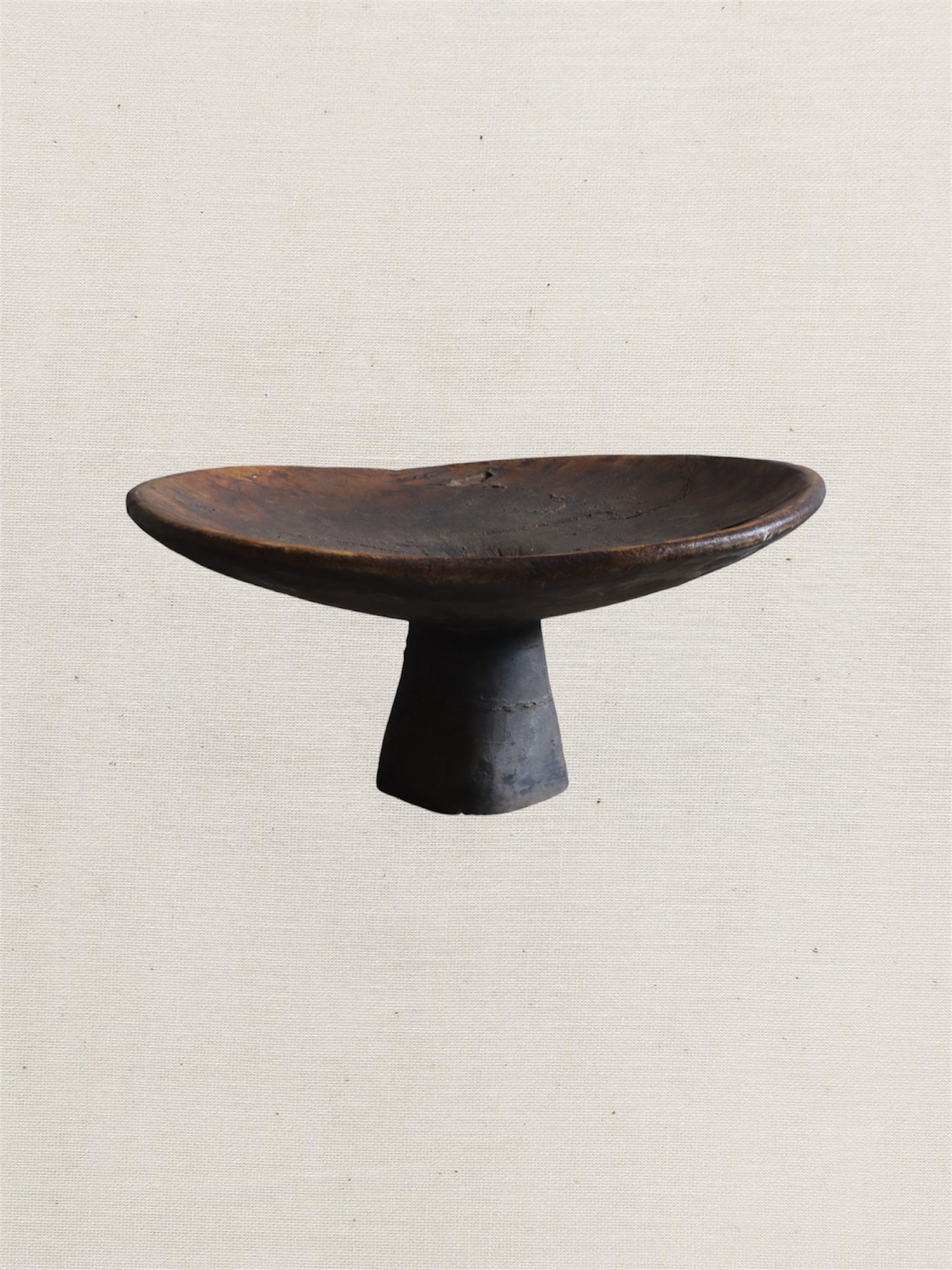Black ceramic pedestal dish on a light beige background