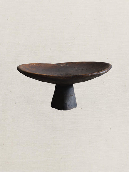 Black ceramic pedestal dish on a light beige background