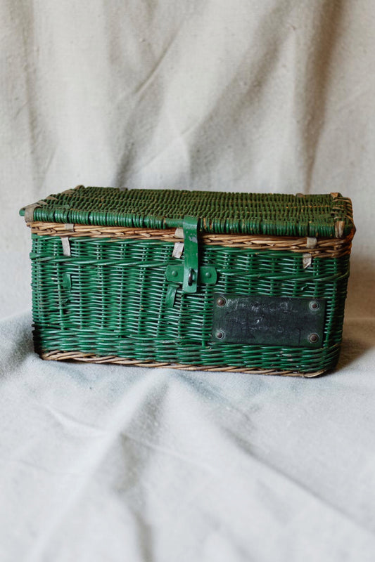 Antique green wicker laundry basket with lid and original black label, full front view
