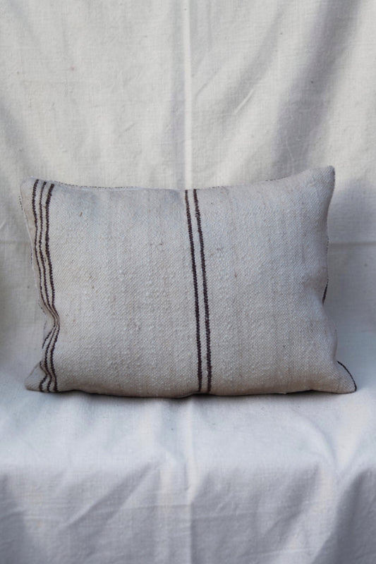Cream Moroccan cushion cover with fine dark brown stripes on a linen backdrop