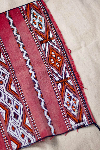 Edge and fringe detail with cream and orange diamond motifs