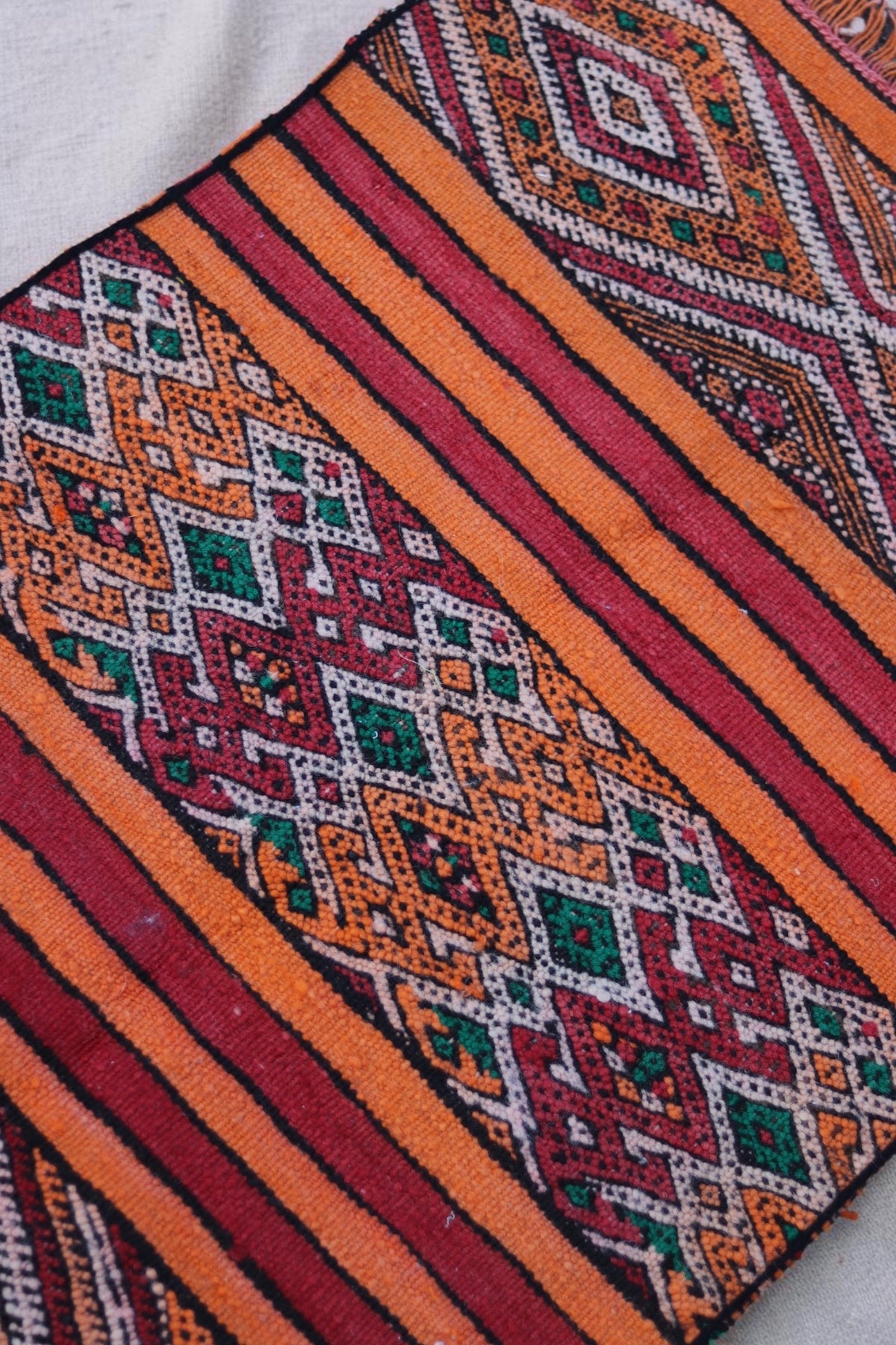 Central geometric band with green accents between orange and red stripes