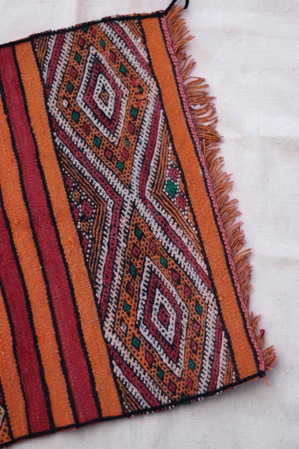 Short orange fringe and geometric end panel on the small Hanbel rug