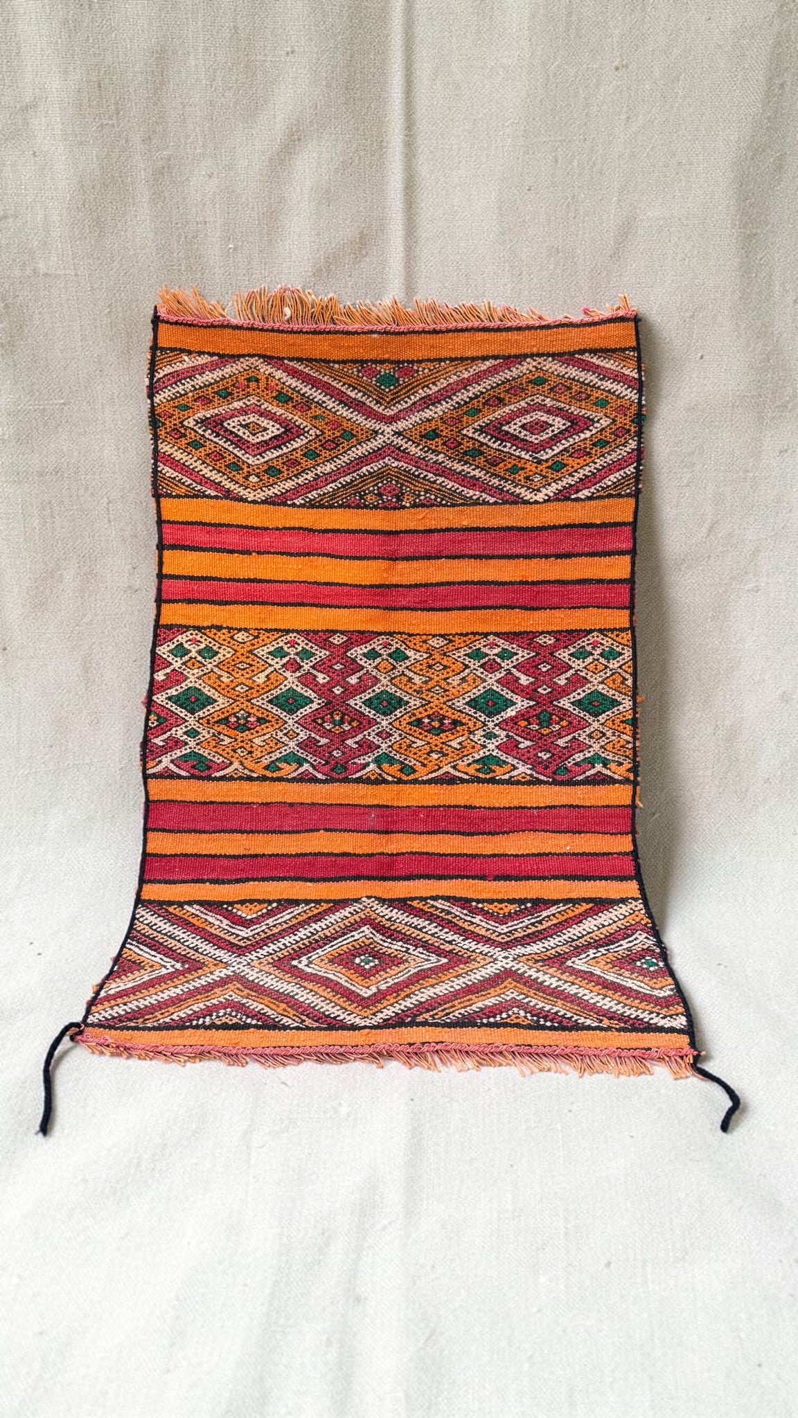 Small vintage Moroccan Hanbel rug with orange and red stripes, cream diamond patterns and green accents