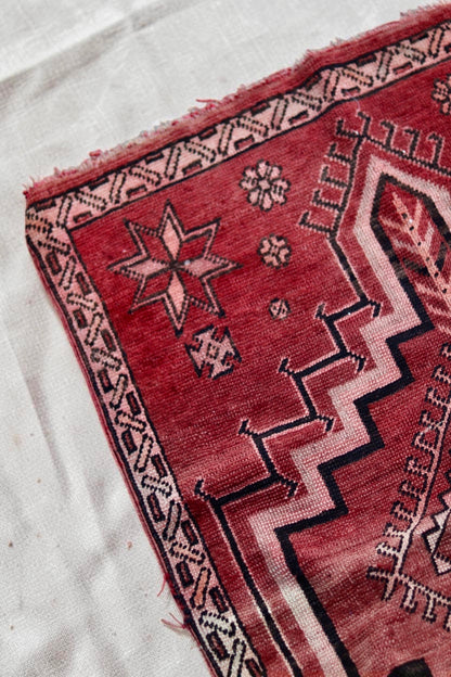 Corner detail with a pink star motif, dark outlines and worn edging