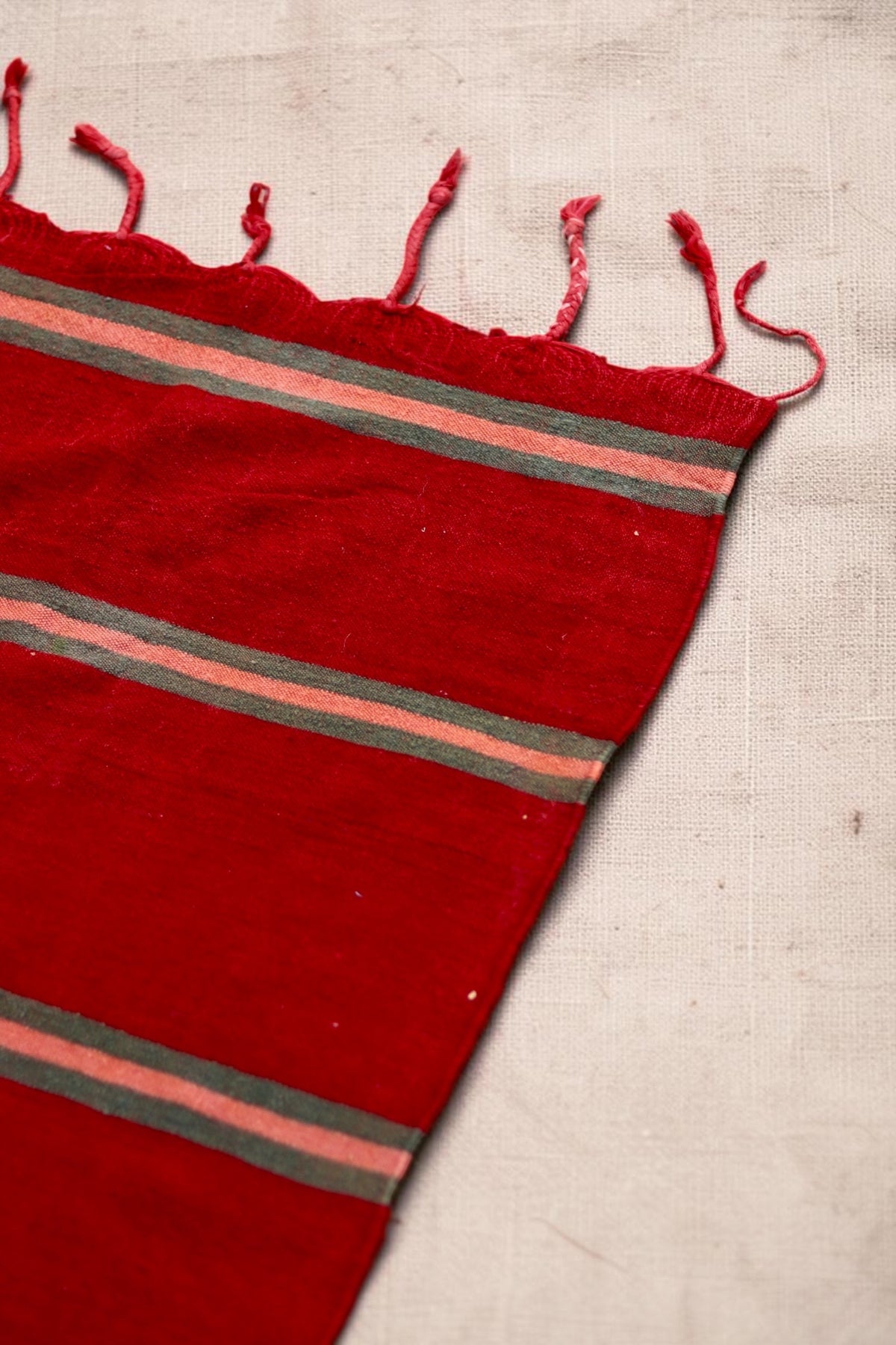 Corner detail showing the red flatweave and knotted tassels