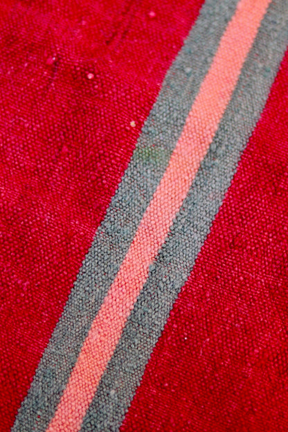 Detailed view of the vintage flatweave texture and pink and grey-green stripes