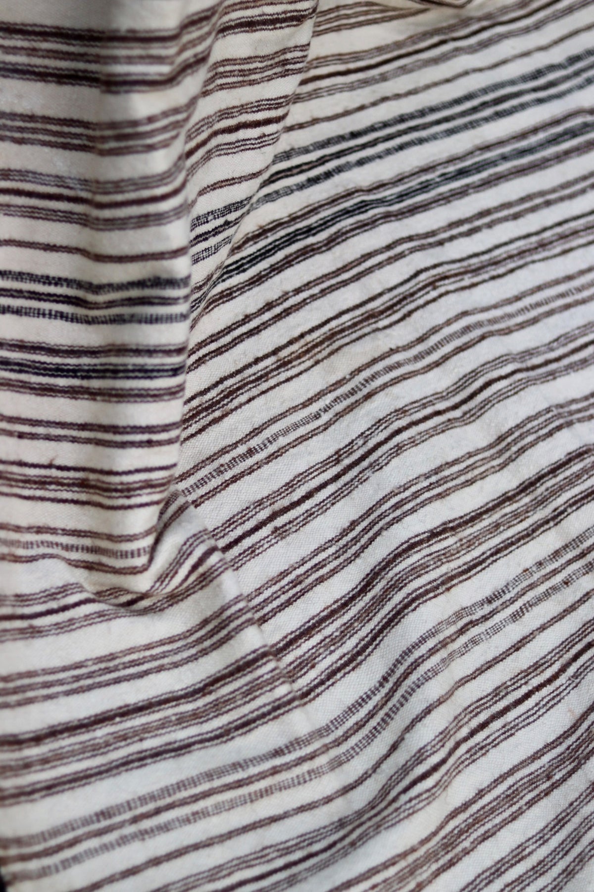 Draped view showing the fine weave of the cream and brown striped textile