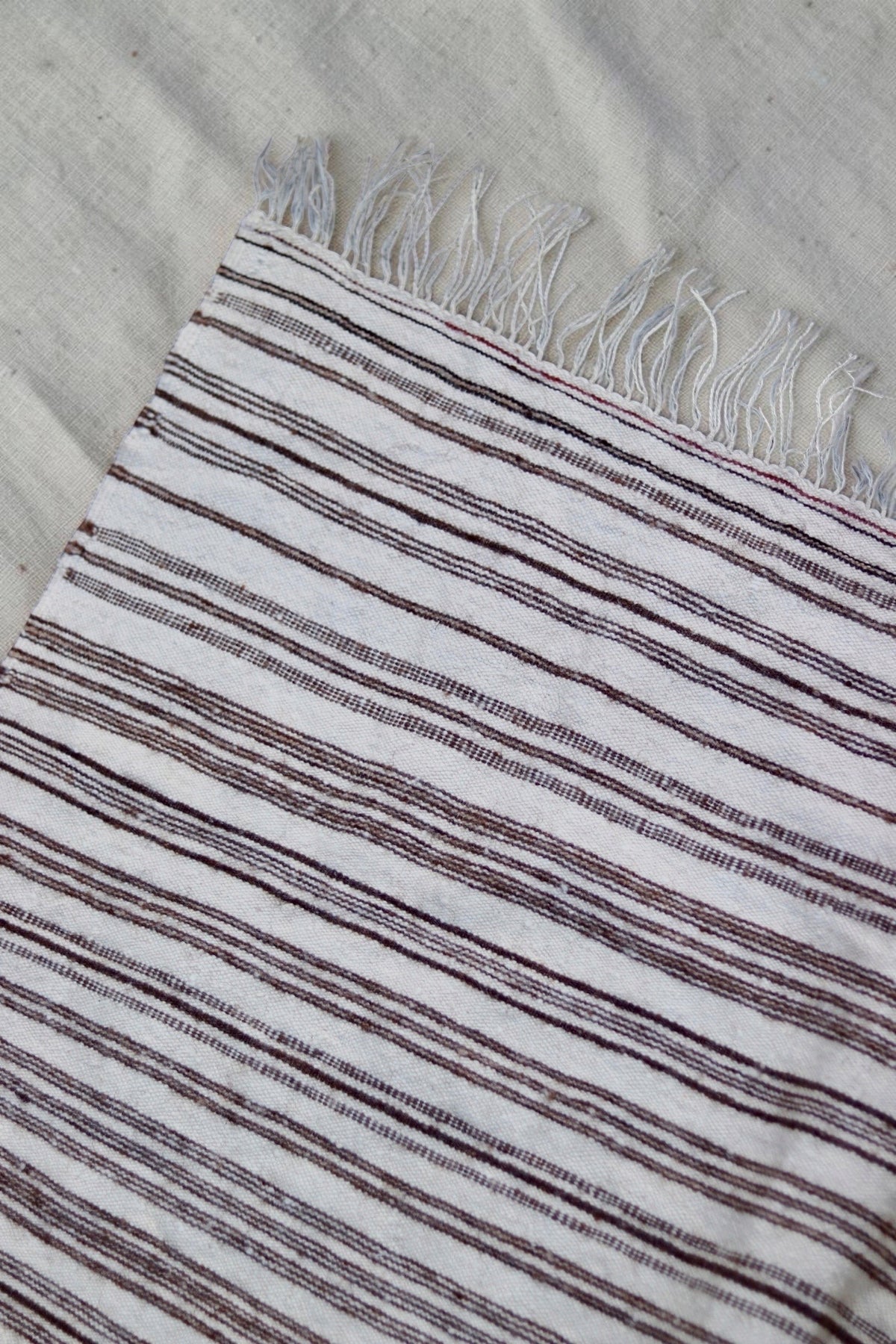 Cream fringe and narrow striped bands on the vintage Moroccan throw