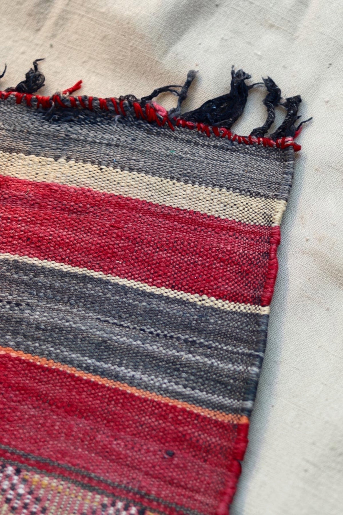 Corner detail showing the striped edge and dark tassels