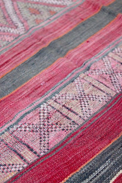 Woven diamond motifs between faded red and charcoal stripes