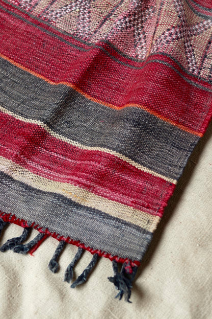 Close view of red and charcoal stripes and dark knotted fringe