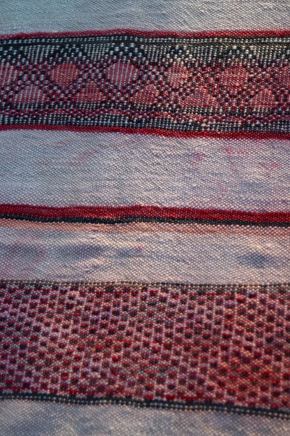 Close-up of rose and charcoal diamond motifs across the cream Hanbel rug