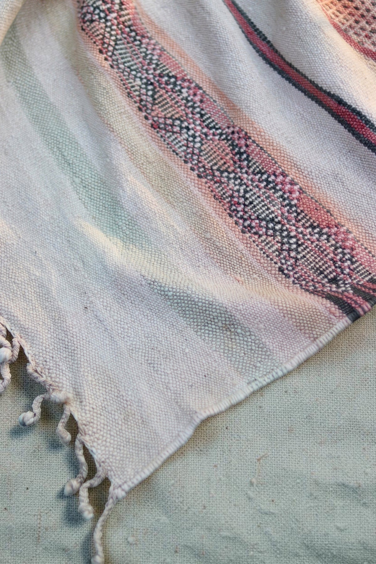 Detail of the geometric border and cream knotted fringe