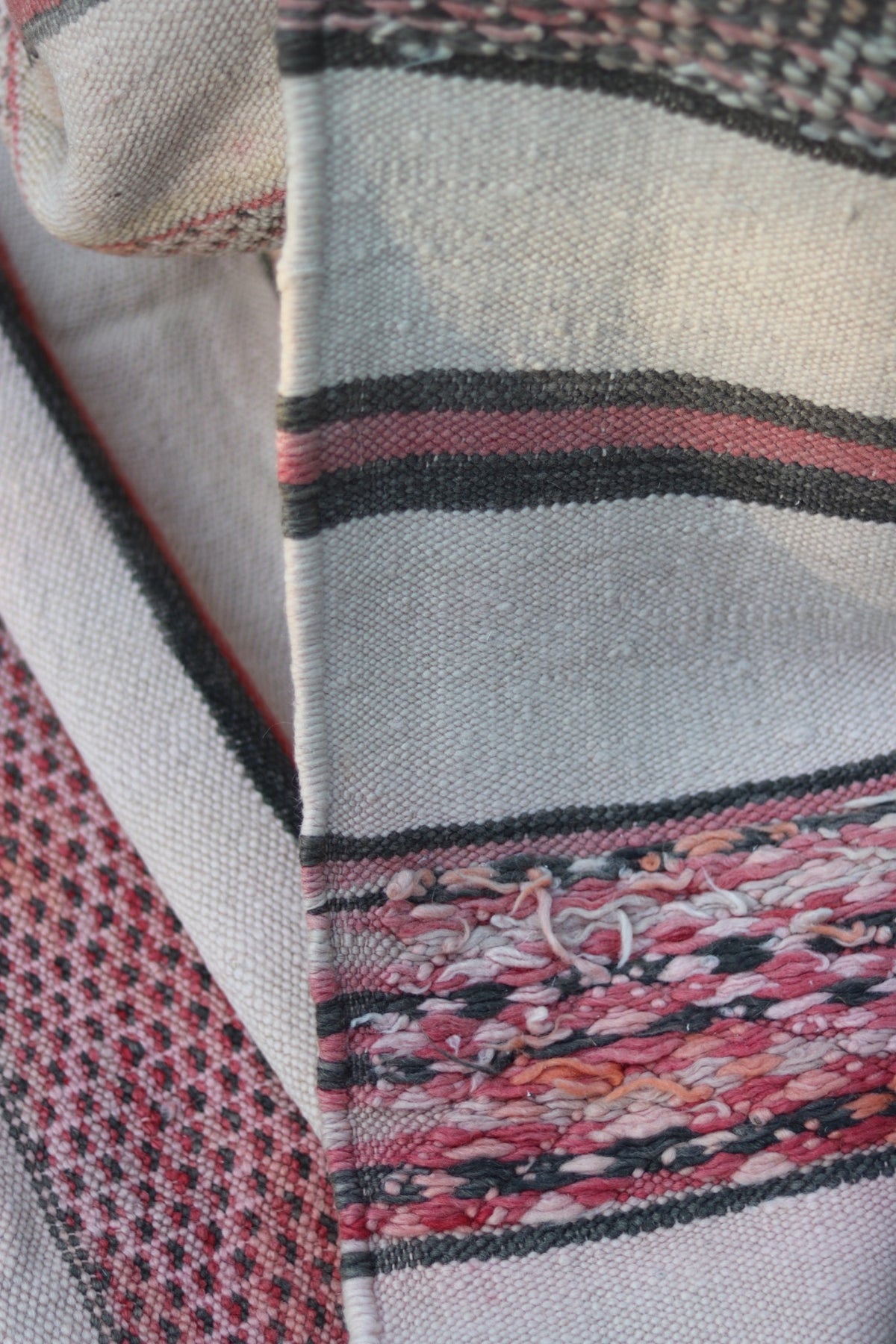 Close-up of the reverse with pink, cream and charcoal yarn ends