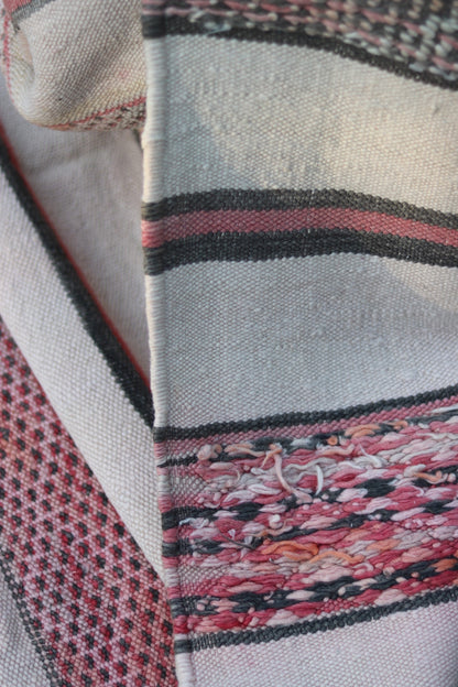 Close-up of the reverse with pink, cream and charcoal yarn ends