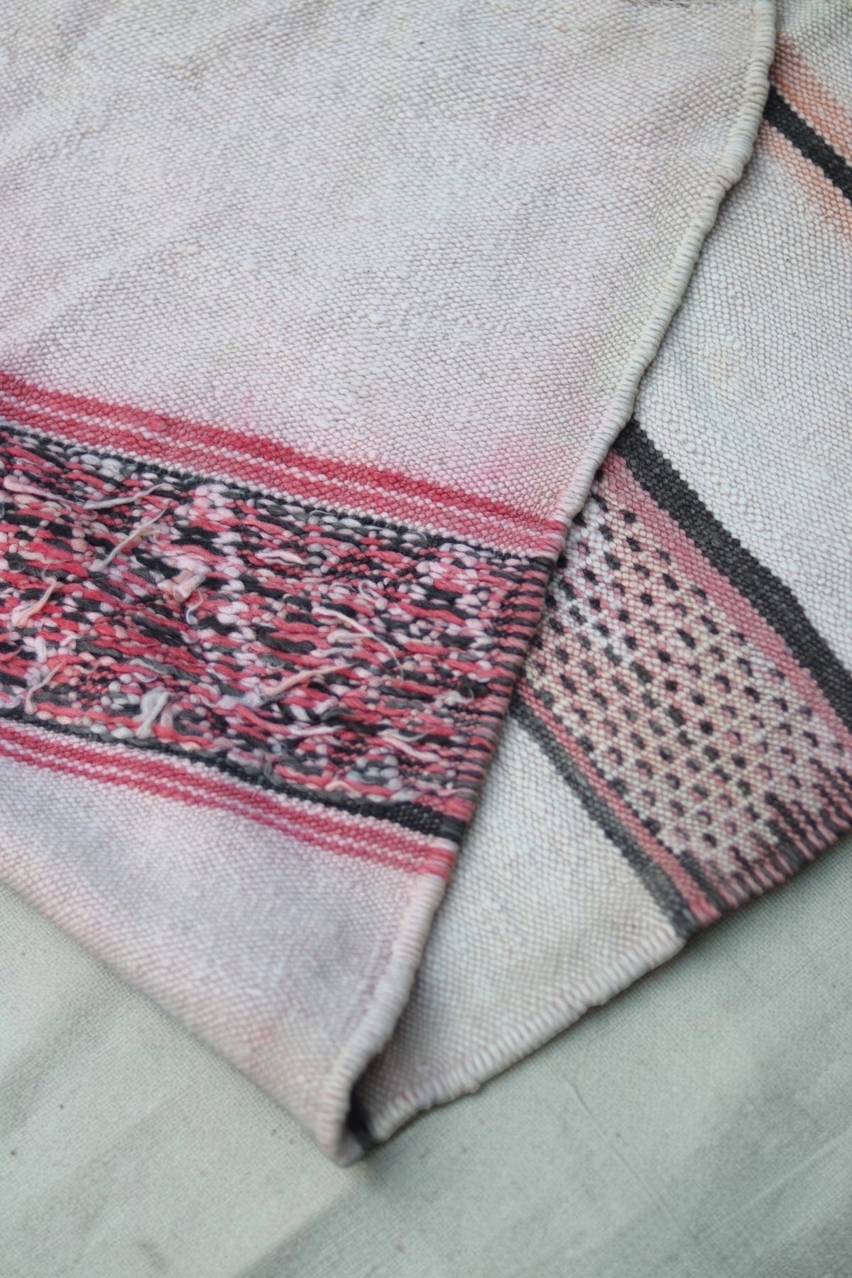 Folded rug showing the patterned face and visible yarn ends on the reverse