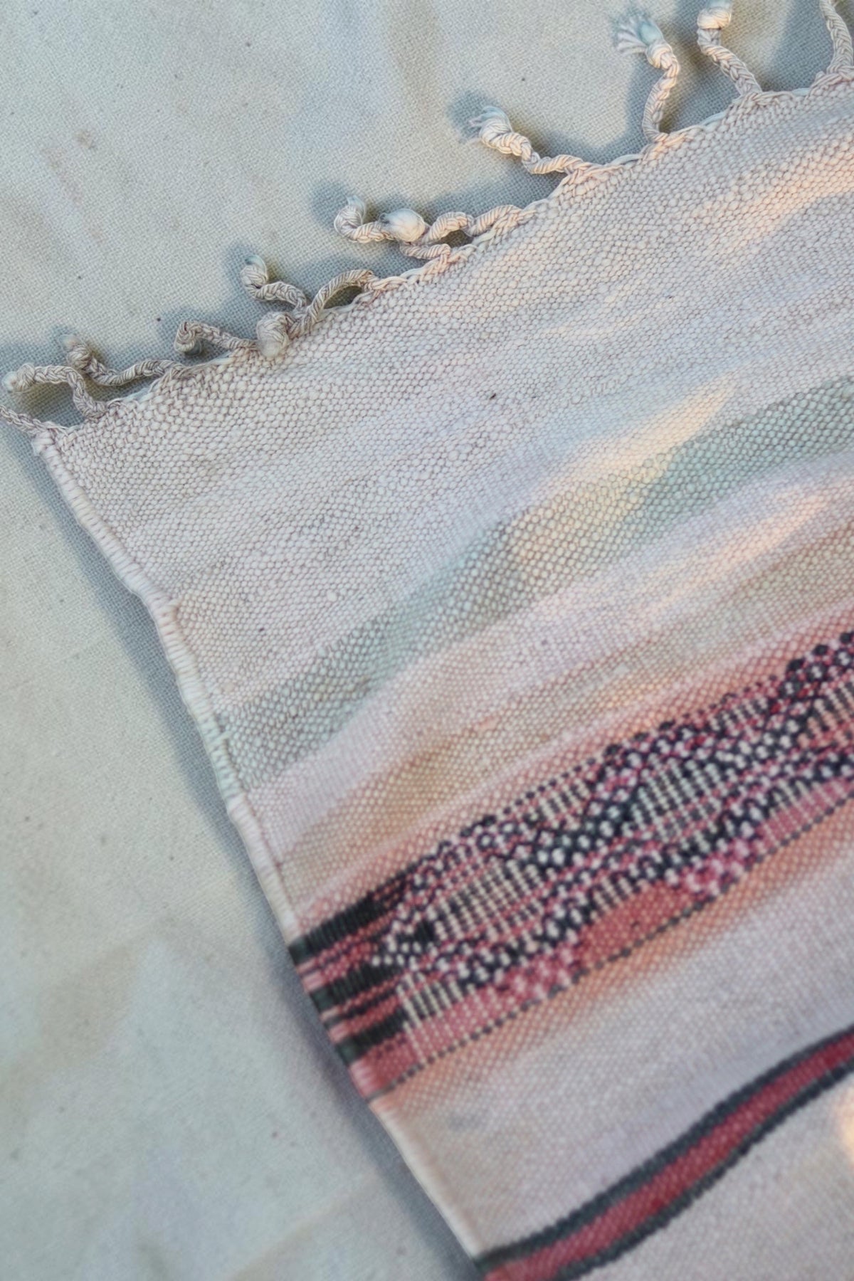 Close-up of the cream fringe and faded colours in the vintage Hanbel weave