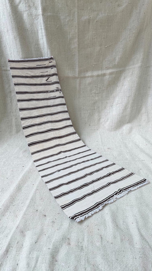 Angled full view of the extra-long cream and brown striped flatweave runner