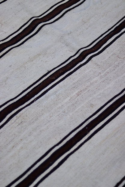 Close-up showing the weave, small marks and tonal variation in the cream ground